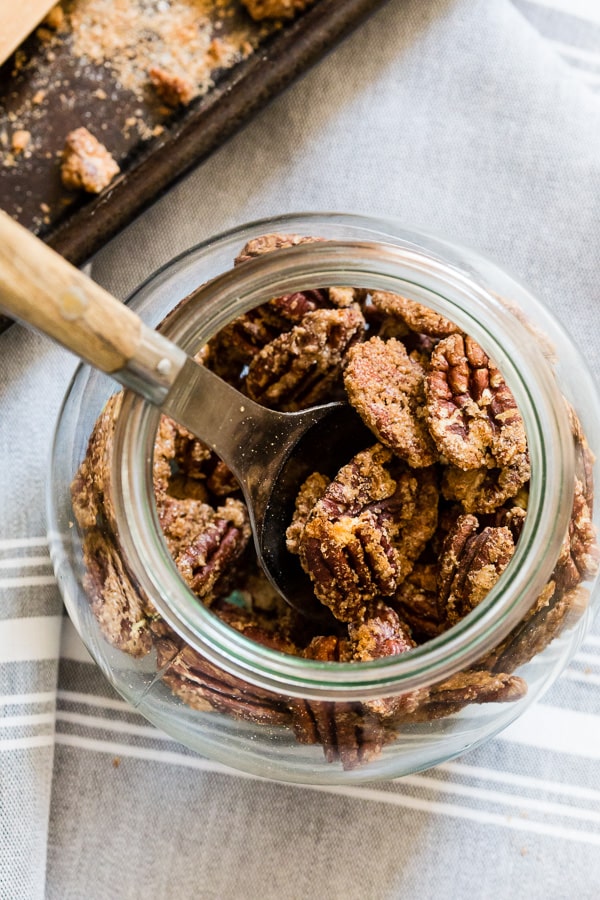 Praline Pecans in a jar with a spoon. 