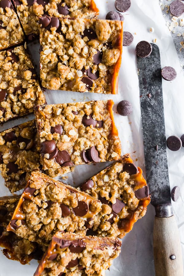 chewy caramel oatmeal bars cut on parchment paper. 