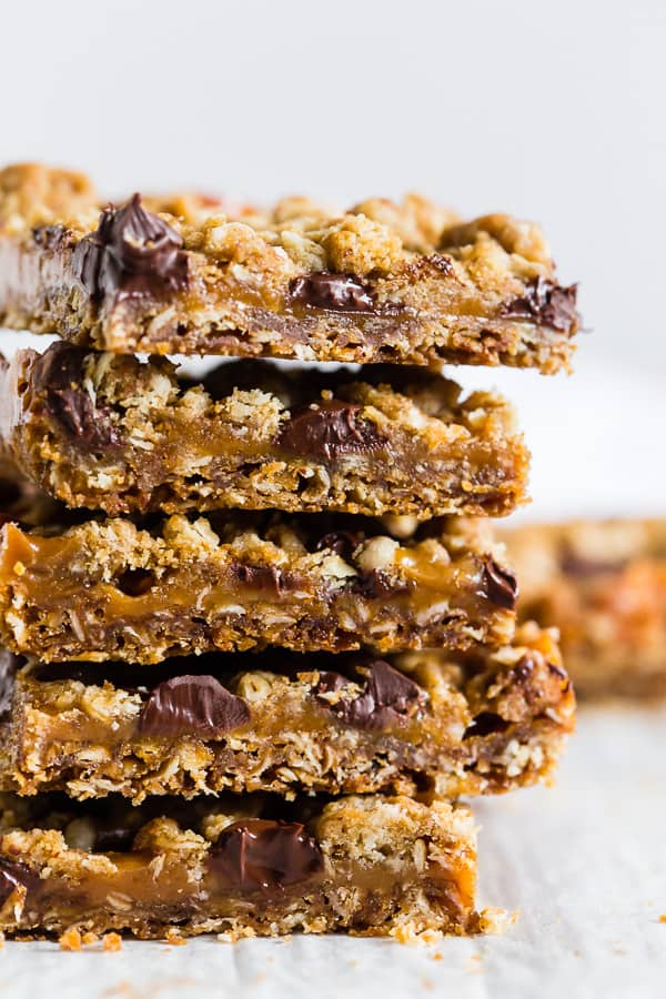 chewy caramel oatmeal bars stacked up to show layers. 