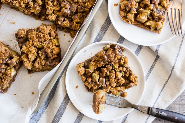 These cinnamon apple streusel bars are the perfect mashup of Dutch apple pie and a crunchy apple bar dessert. Super simple to make and sure to be the hit of any party or family gathering. Plus you're going to love the drizzle of vanilla bean maple glaze. 