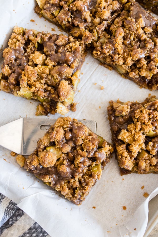 These cinnamon apple streusel bars are the perfect mashup of Dutch apple pie and a crunchy apple bar dessert. Super simple to make and sure to be the hit of any party or family gathering. Plus you're going to love the drizzle of vanilla bean maple glaze. 