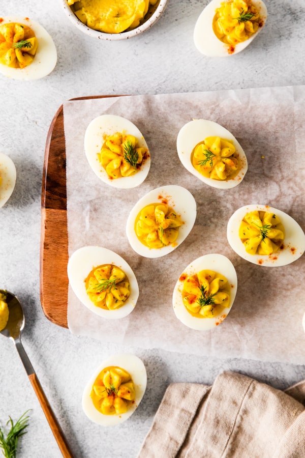 Classic Deviled Eggs served on a wooden cutting board. 