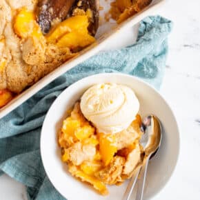 a bowl full of frozen peach cobbler with ice cream