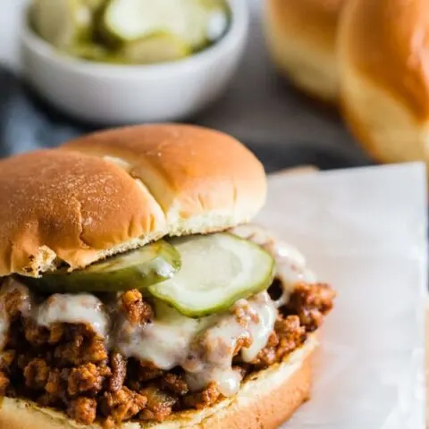 These sloppy Cubanos are the perfect spin to the traditional Sloppy Joe. A delicious mixture of ground pork, chorizo, spices, lime, and tomato piled high on a bun and topped with Swiss cheese and pickles. It's the perfect mashup of a Cuban sandwich and Sloppy Joe. 