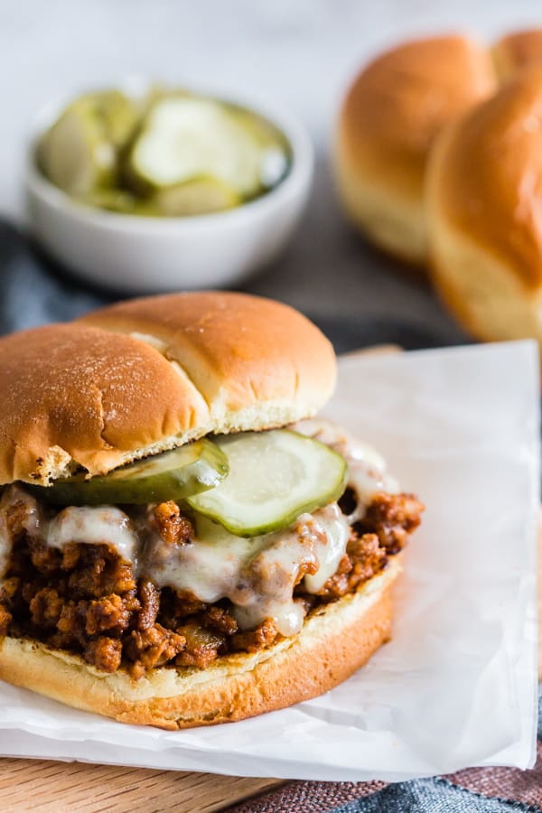 Sloppy Cubanos topped with pickles. 