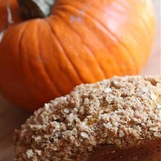 crumble topped pumpkin bread with a pumpkin in the background