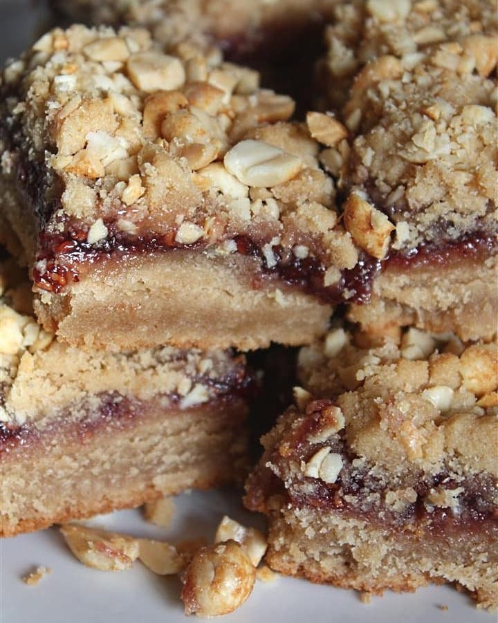 These peanut butter and jelly bars are the perfect dessert version of your favorite childhood sandwich. A peanut butter cookie base is topped with raspberry jam and salty chopped peanuts. You'll love this easy sweet treat!