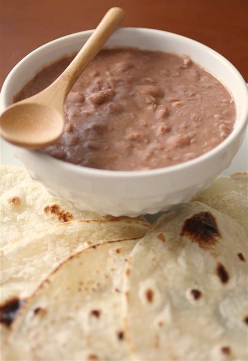 These Southern style pinto beans only take 4 ingredients and cost less than $5 to make! They are perfect eaten plain or rolled up in a soft flour tortilla.