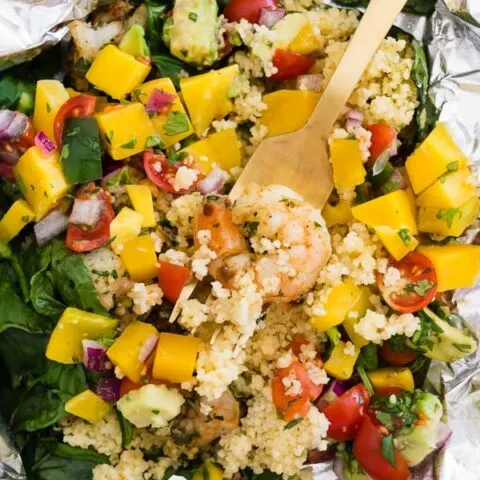These shrimp couscous packets with avocado mango salsa are the perfect throw it together dinner. All you need to do is wrap it all up in foil, bake or grill and top with salsa. So easy and totally delicious! Ready in under 30 minutes! 