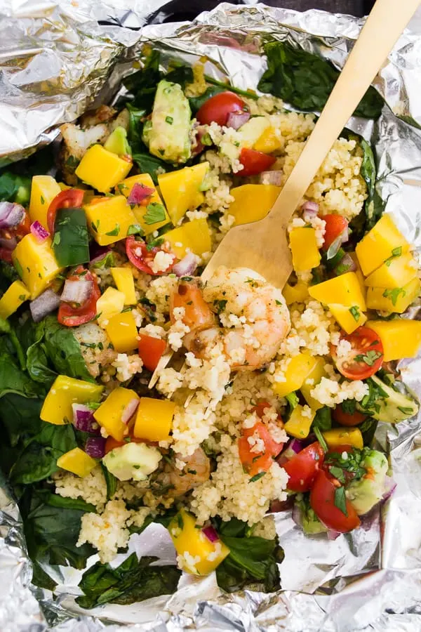 These shrimp couscous packets with avocado mango salsa are the perfect throw it together dinner. All you need to do is wrap it all up in foil, bake or grill and top with salsa. So easy and totally delicious! Ready in under 30 minutes! 