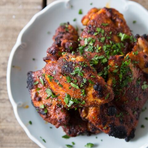 honey spiced glazed chicken thighs on a plate sprinkled with parsley