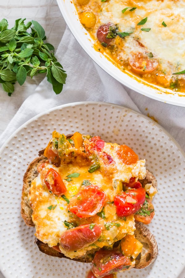 Bruschetta Baked Eggs served on a plate with toast. 