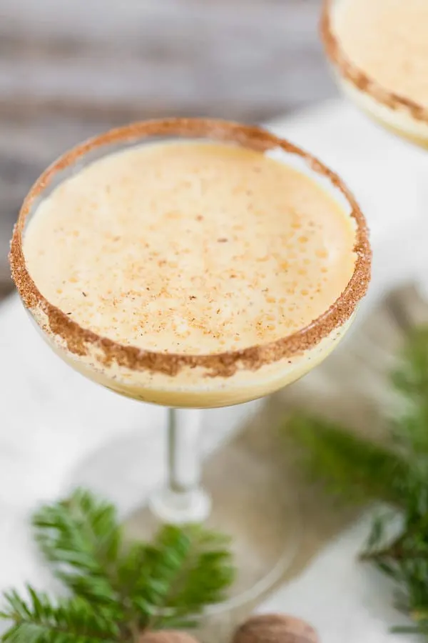 Eggnog martini with a cinnamon sugar rim and topped with nutmeg