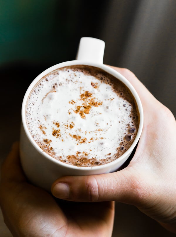 a hand holding Vitamix hot chocolate in a mug