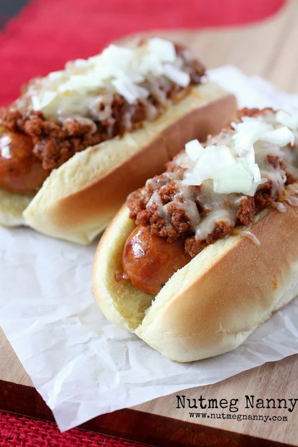 These spicy andouille chili dogs are topped with a homemade chili meat sauce, cheese and just a sprinkling of onions. Spicy and delicious!