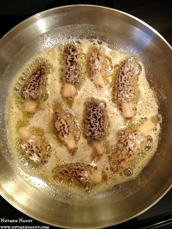 Morel mushrooms frying in a pan with butter.
