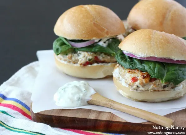 These Greek chicken burgers are slathered with Greek yogurt sauce and and homemade quick pickled red onions. This sandwich is packed full of flavor!