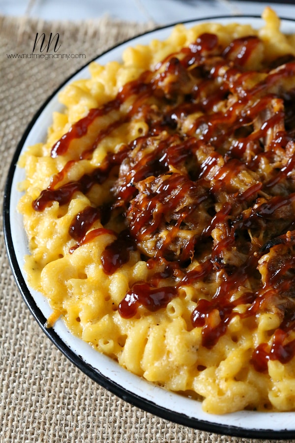 pulled pork mac and cheese in a white dish drizzled with bbq sauce