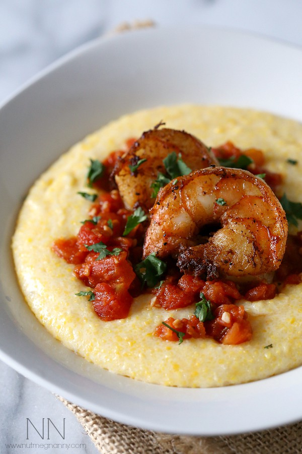 Spicy Shrimp Over Creamy Polenta in a bowl topped with fresh herbs.