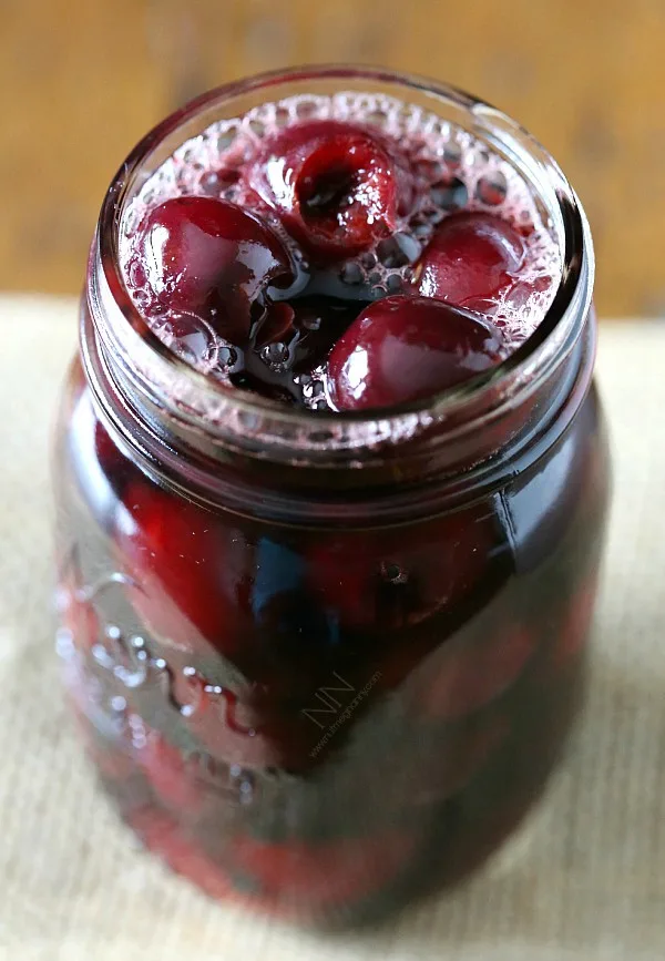 Quart glass jar full of pickled cherries.