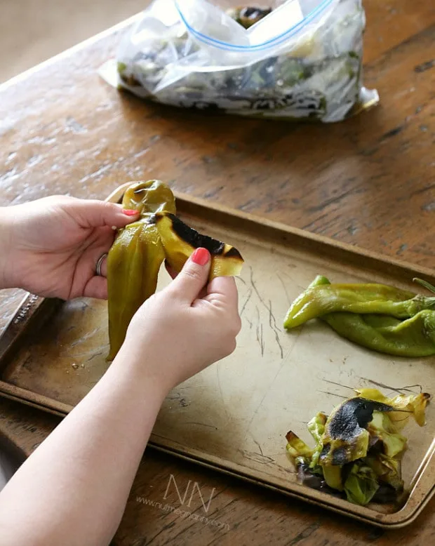 peeling off the charred skin on a roasted hatch green chiles.