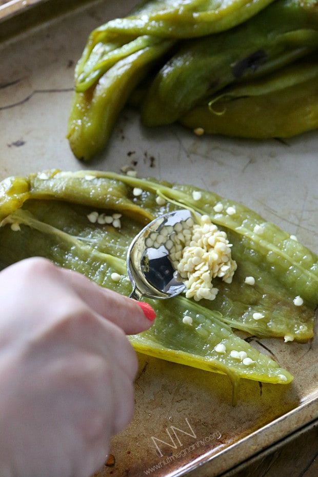 scooping out the seeds of a roasted hatch green chile.