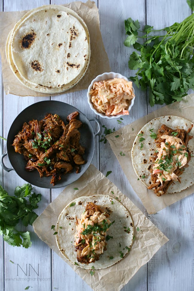 These slow cooker ginger beer pulled pork tacos are topped with a spicy chipotle cole slaw and served on toasted corn tortillas.