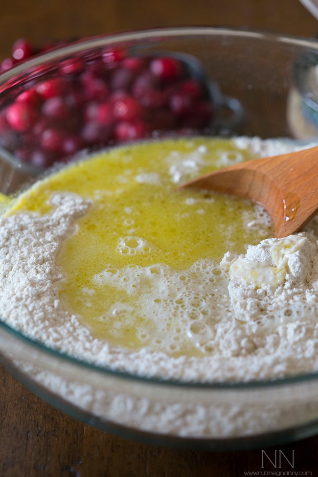 Olive oil being added to a bowl with flour to make Cranberry Rosemary Focaccia. 