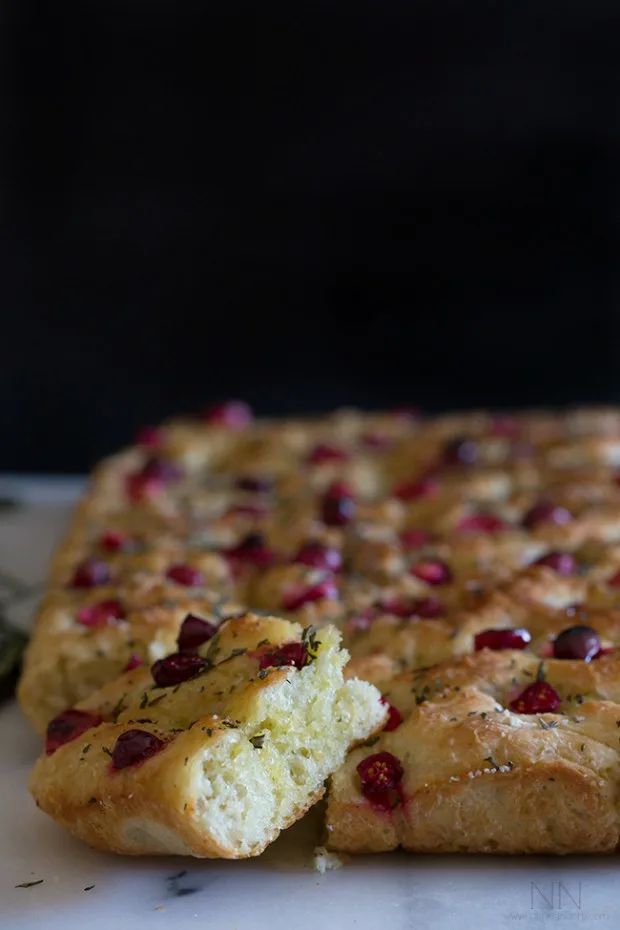 Cranberry Rosemary Focaccia sliced on a marble tray. 