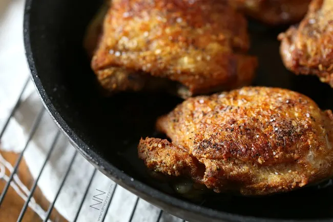 crispy pan roasted chicken thighs in a small skillet