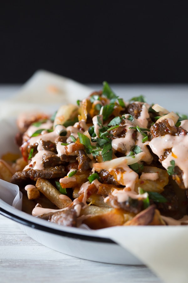 These totally loaded kimchi fries are the best appetizer ever! Super simple seasoned stir-fry beef mixed with sauteed kimchi topped over crispy cheese covered french fries. What's not to love?