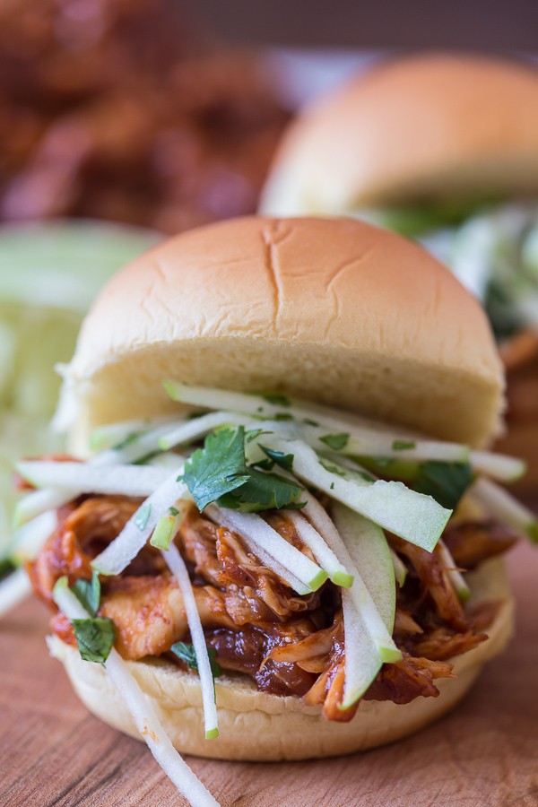 This apple butter bbq chicken sandwich is made with a homemade apple butter bbq sauce, roasted chicken breast and topped with a tangy green apple cilantro slaw.