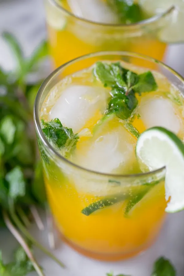 mango mojito in a glass garnished with fresh lime slice