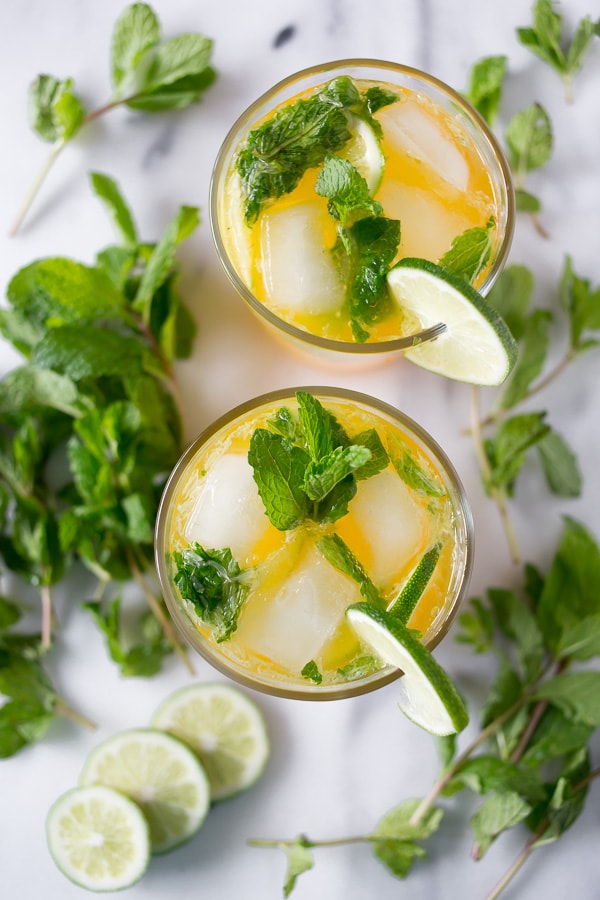mango mojito in a glass style on a marble cutting board with fresh mind and limes