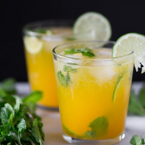mango mojito in a short cocktail glass garnished with fresh lime and mint