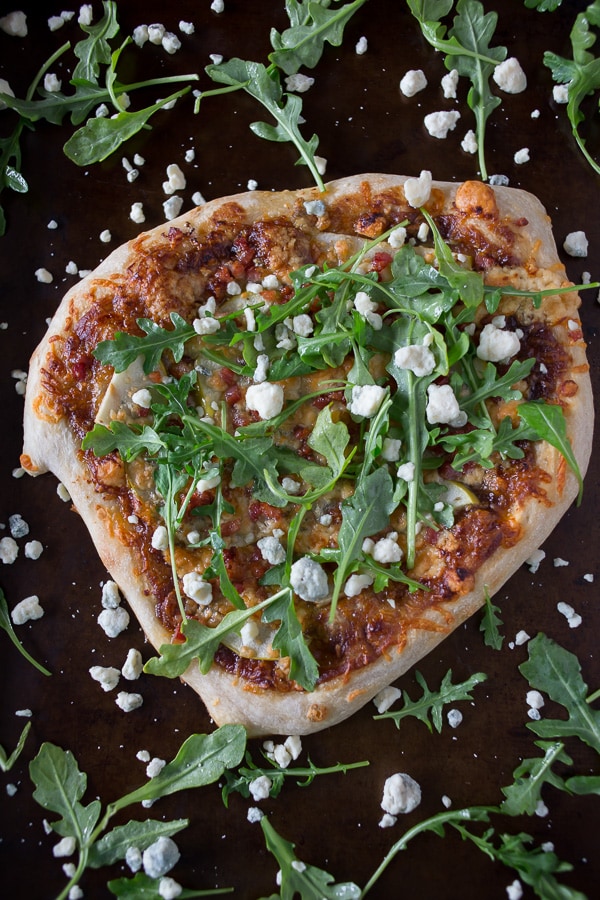 Homemade pizza topped with arugula and blue cheese.