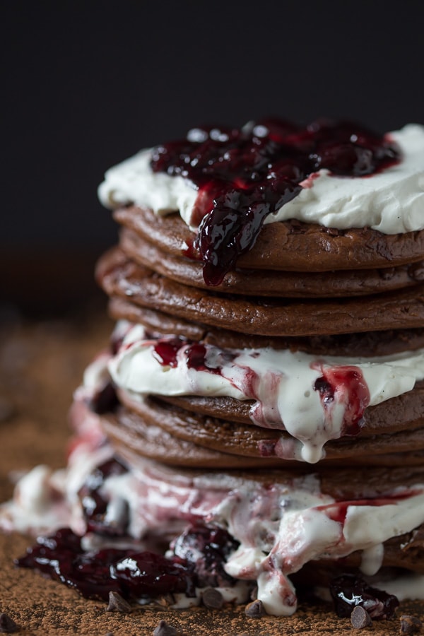 These super fluffy and easy gluten free black forest pancakes are layered with sweet breakfast flavor. Super chocolaty gluten free pancakes paired with cherries and vanilla whipped cream.