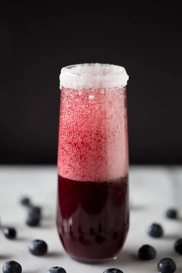This mixed berry bellini is perfectly sweet and and packed full of blueberry and strawberry flavor. Served with a sugar rim and topped with sweet sparkling wine or prosecco.