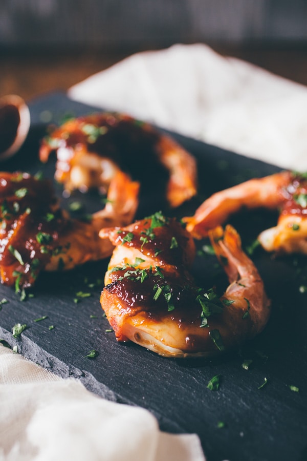 These apple butter bacon wrapped shrimp are the perfect summer appetizer. Extra large shrimp wrapped in bacon and glazed with a sweet and spicy apple butter glaze.