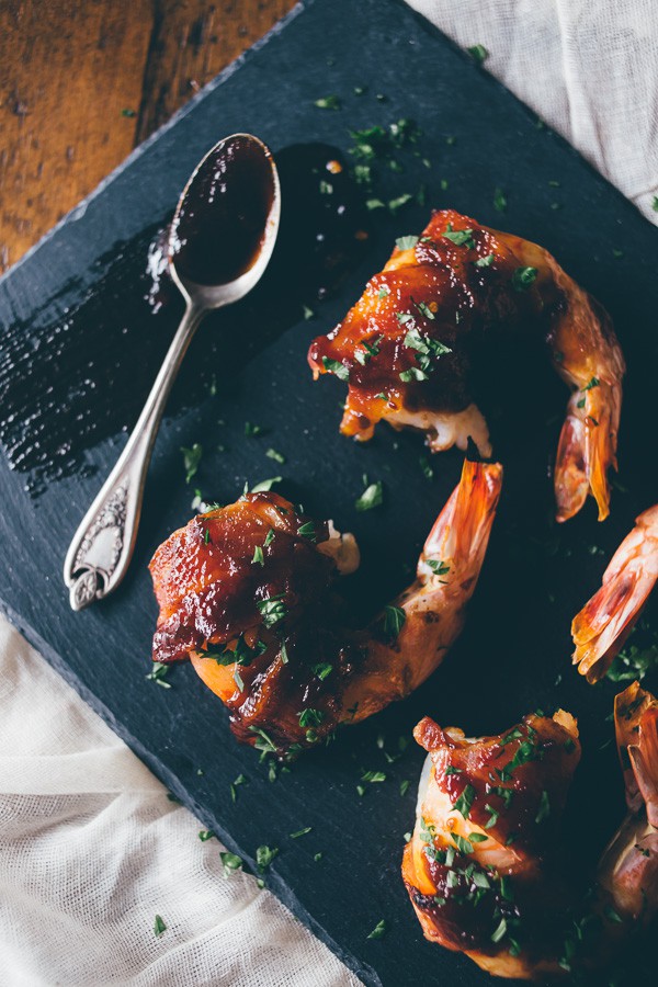 These apple butter bacon wrapped shrimp are the perfect summer appetizer. Extra large shrimp wrapped in bacon and glazed with a sweet and spicy apple butter glaze.