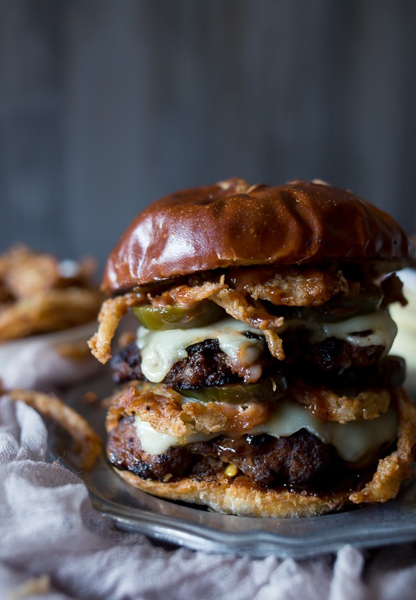 This chorizo beef burger with crispy onion straws is the perfect big mouth burger. Topped with bbq fry sauce, candied jalapeños and American cheese. 