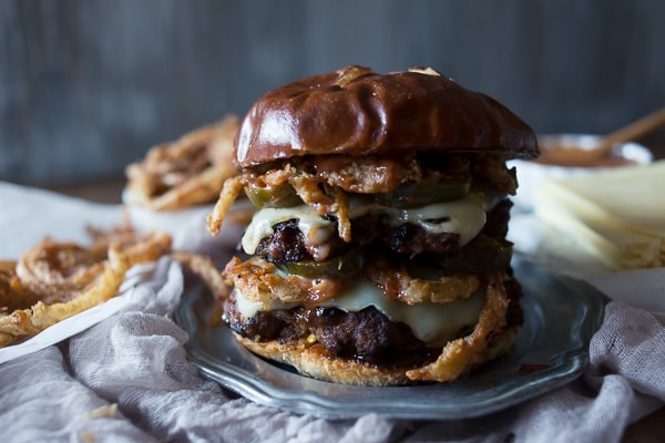 This chorizo beef burger with crispy onion straws is the perfect big mouth burger. Topped with bbq fry sauce, candied jalapeños and American cheese. 