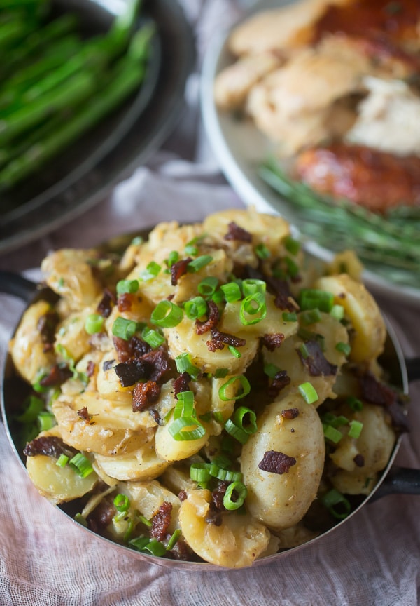 This warm bacon herb potato salad is the perfect winter side dish. It's the perfect balance of tangy and sweet and ready in just about 30 minutes. Made with soft potatoes, bacon, sautéed onions, garlic, fresh herbs and tossed in a tangy apple cider vinaigrette dressing. 
