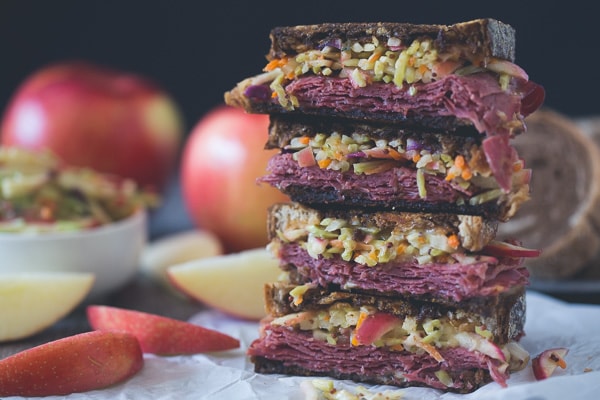 This tangy apple slaw corned beef reuben is the perfect fall sandwich. Perfectly toasted marble rye topped with an apple cabbage slaw, corned beef, melted swiss cheese and lots of homemade Russian dressing.