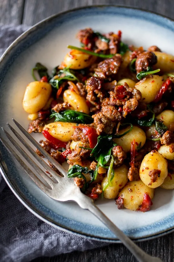 chorizo roasted red pepper spinach gnocchi on a plate with a fork