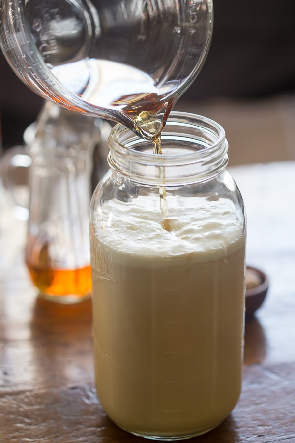 Pouring aged eggnog into a glass jar. 