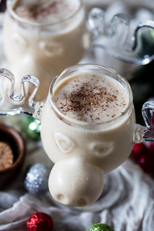 A glass of aged eggnog served in a glass with nutmeg on top. 