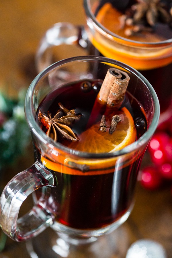 Slow Cooker Spiced Mulled Wine in a glass with an orange slice. 