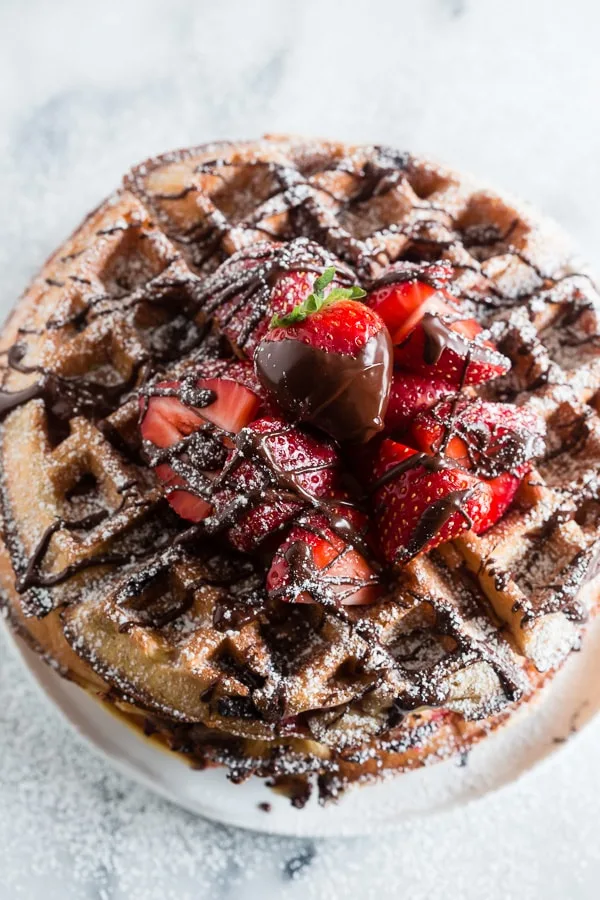 These chocolate covered strawberry buttermilk waffles are the best breakfast you will ever have! Fresh berries tucked inside a fluffy buttermilk waffle and then drizzled with melted chocolate. How can you not love that?