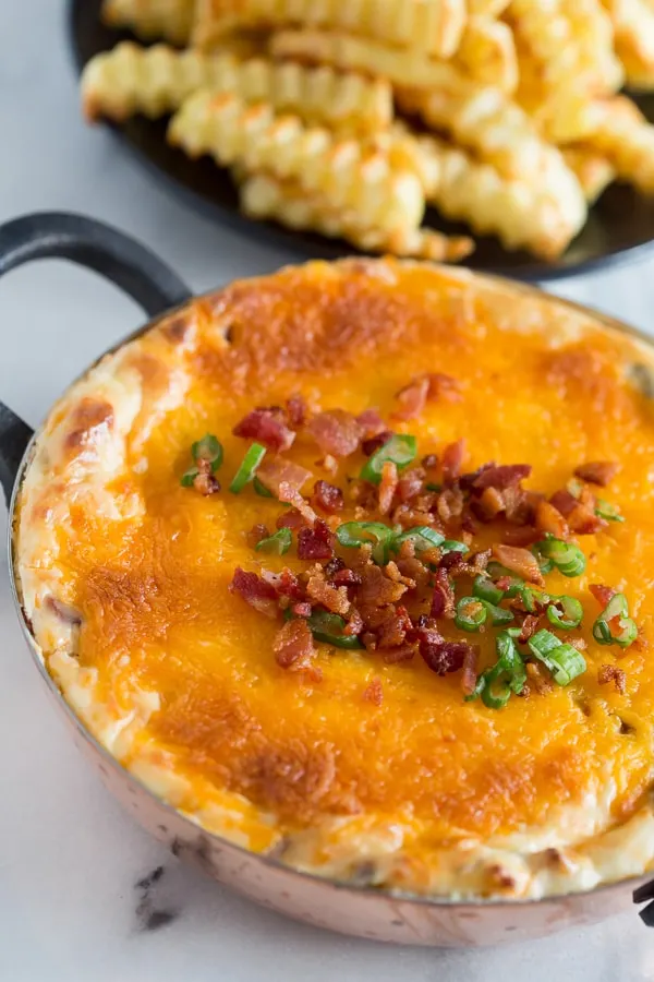 warm loaded baked potato dip topped with bacon and green onions. 